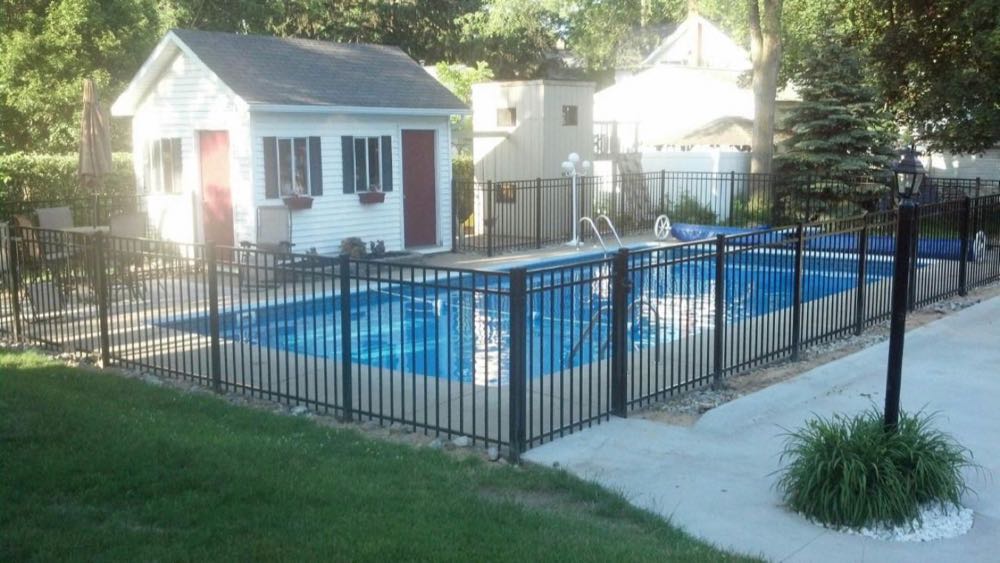 Black aluminum fence around a backyard pool