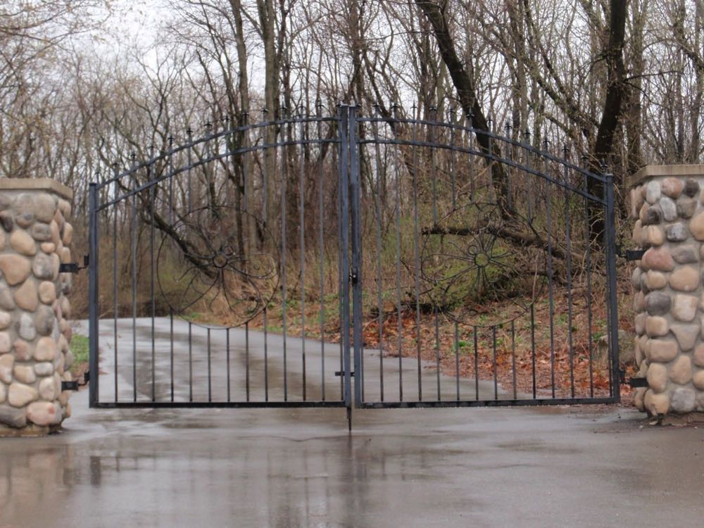 Wrought iron gate set between fieldstone pillars
