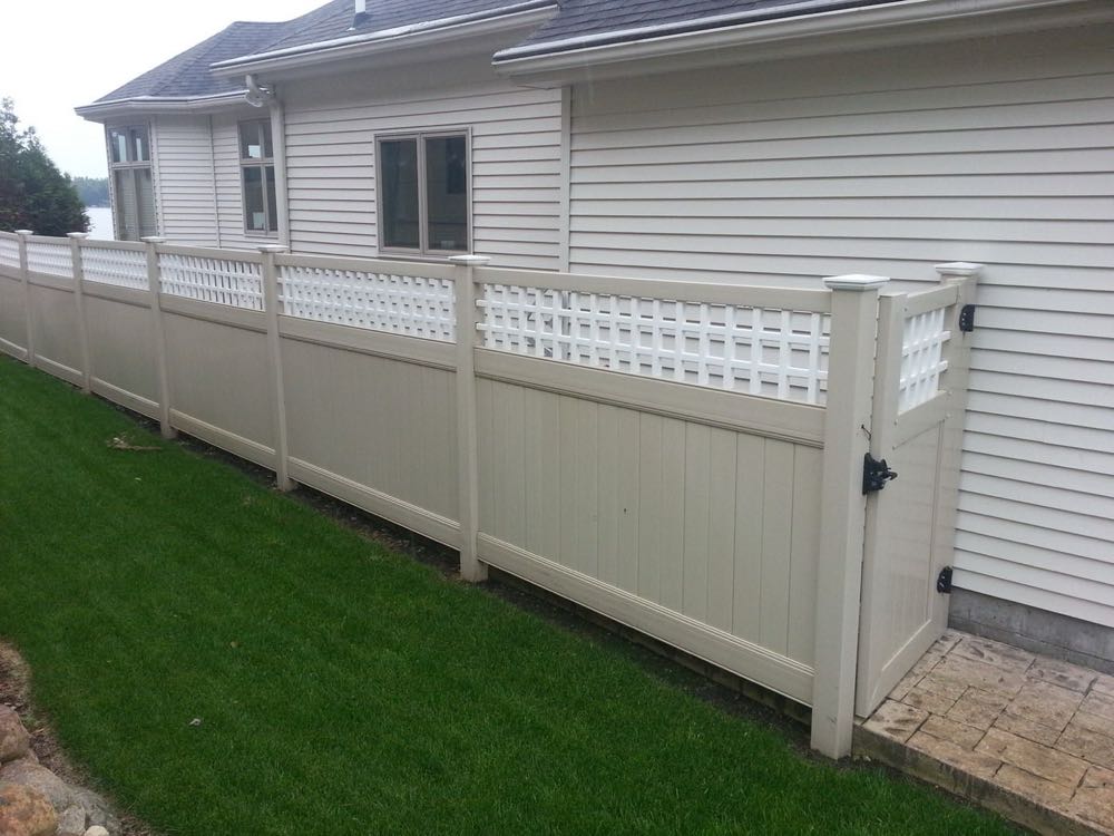 White vinyl privacy fence with lattice top beside a house