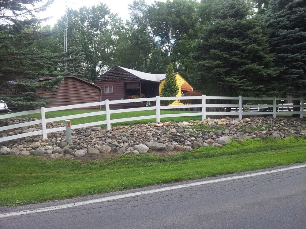 White vinyl ranch rail fence along a road